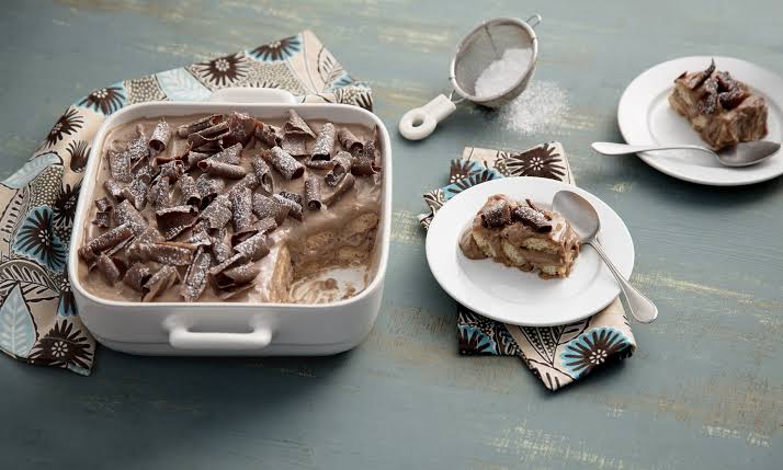 Pavê de chocolate em camadas, com biscoitos dourados e cobertura brilhante, servido em prato branco